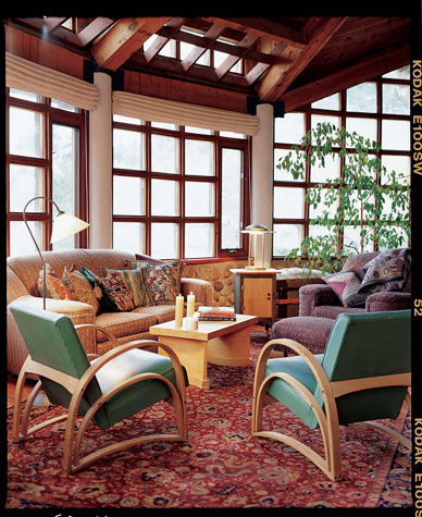 A grand sweep of glass panes recycled from an old greenhouse lets Susan and Tom and their family bask in sunshine from sunup to sundown during the winter months.